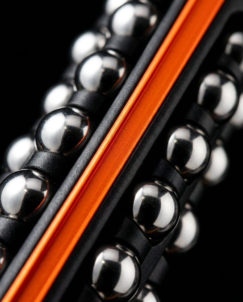 Macro of the bright orange anodized rail between rows of chrome massage balls