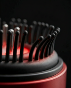 Macro of the soft black silicone bristles on the red scalp comb