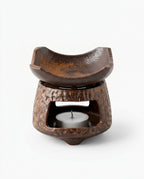 Dark brown ceramic oil burner with curved dish, front view on white