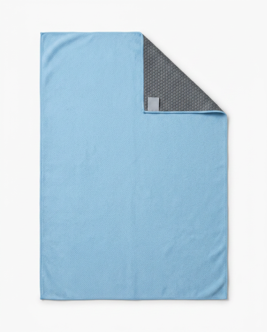 Sky blue yoga towel flat-laid with corner folded to show gray grip backing