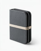 Grey stone bath mat folded compactly and held with a strap for travel