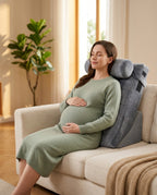 Pregnant woman reclining on sofa against grey wedge support pillow