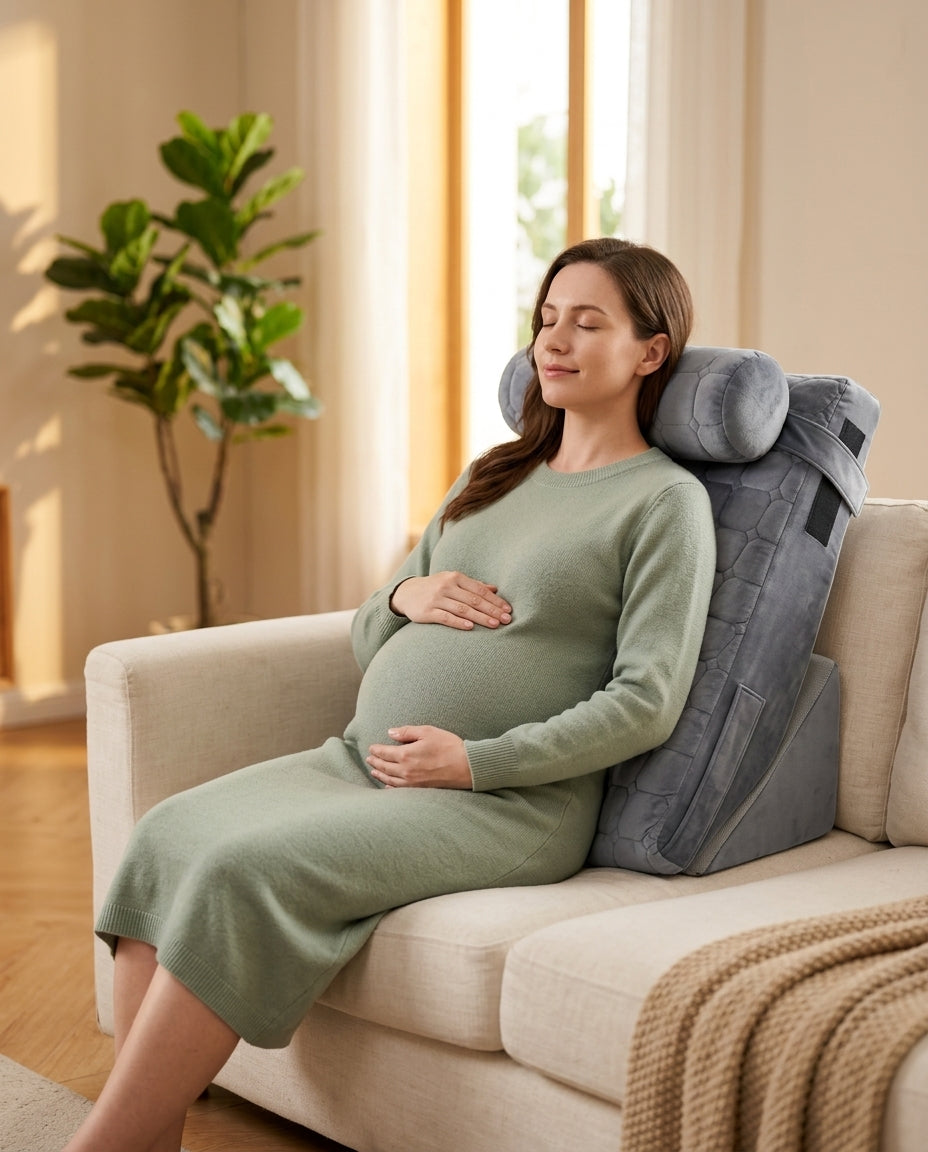 Pregnant woman reclining on sofa against grey wedge support pillow