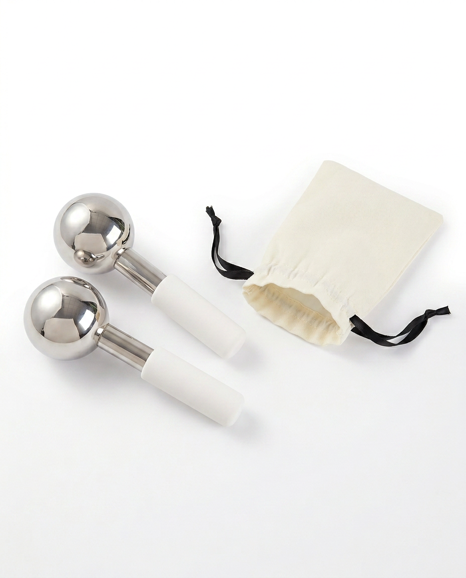 Two facial ice globes beside a cream drawstring storage pouch on white