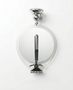 Front view of the round shower mirror with suction mount above and razor hook below