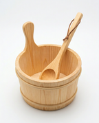 Empty pine sauna bucket with ladle resting inside, studio packshot on white