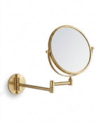 Brushed gold wall-mounted vanity mirror on extendable arm, on white background