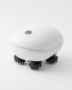 White electric scalp massager with black silicone claws on white background