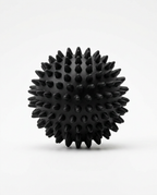 Black spiky recovery massage ball, studio packshot on white