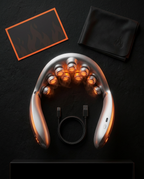 Flat lay of the neck massager with charging cable and pouch in the box