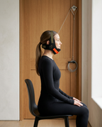 Side profile of a woman seated in the neck halter with upright spine alignment