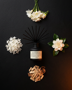 Flat lay of the reed diffuser with white flowers and cinnamon, scent family