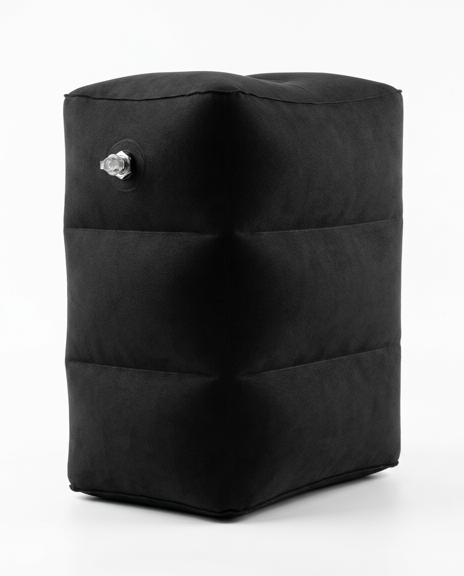 Black inflatable travel footrest pillow with air valve, studio shot on white