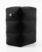 Black inflatable travel footrest pillow with air valve, studio shot on white