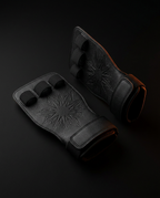 Pair of black grip pads with starburst palm pattern and orange trim