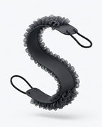Black back scrubber curved into an S-shape showing silicone backbone and loops