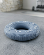 Blue-gray grip strengthener ring resting on a concrete gym floor