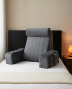 Grey velvet bed rest pillow placed against a headboard on a white bed