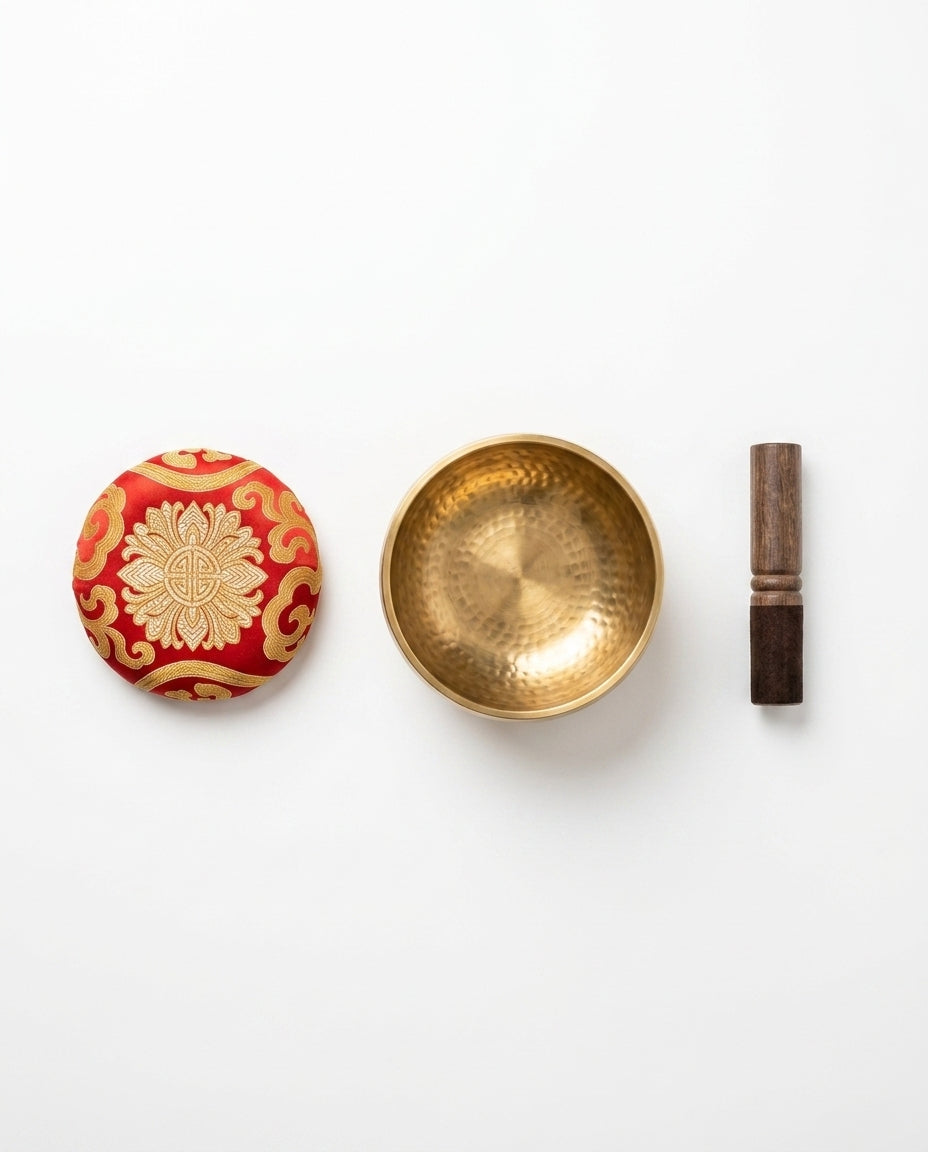 What's-in-the-box flat lay: singing bowl, red silk cushion and wooden striker