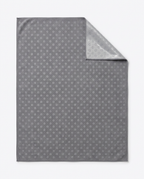 Gray yoga towel showing silicone grip-dot pattern with corner folded