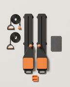 Black pro pilates board with orange pads and resistance bands, flat-lay
