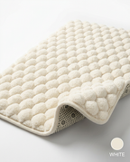 Cream white pebble memory foam bath mat with folded corner, labeled White