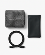 Flat-lay of folded gray wrap with black travel pouch and USB-C cable