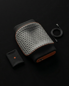 Top-down in-box view of neck pillow with USB cable and storage pouch