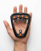 Finger trainer resting in an open palm showing its compact size on white