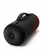 Three-quarter packshot of the black velvet bolster with tufted end and handle