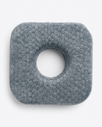 Top-down view of the grey ear piercing pillow with central hole on white