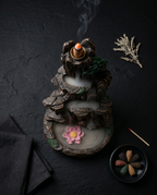 Flatlay of the incense holder with cones and matches on dark linen