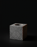Three-quarter view of the dark granite oil holder cube on black