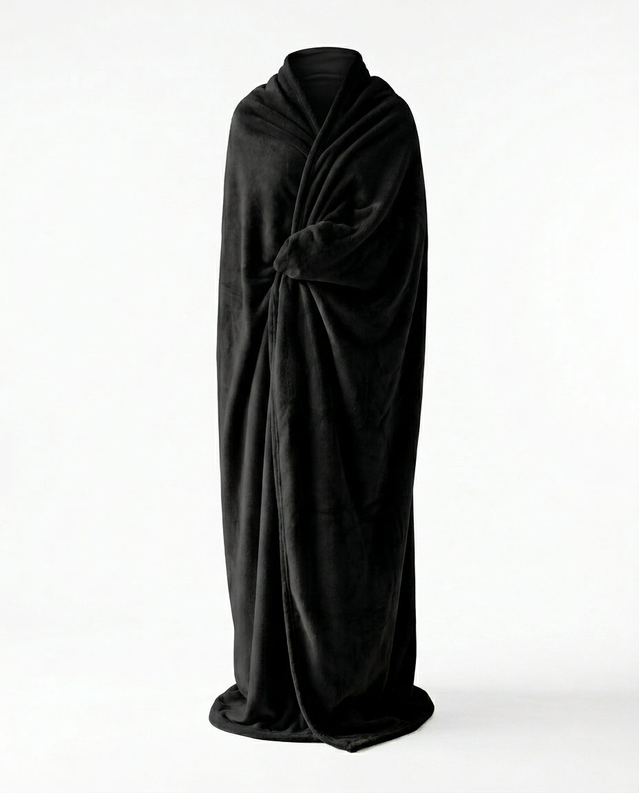 Person wrapped in a black wearable blanket, studio shot