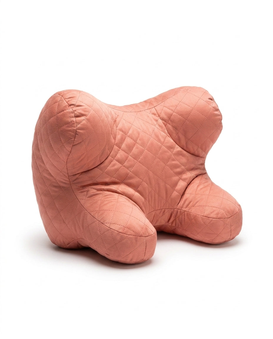 Coral pink quilted support pillow on white, three-quarter view