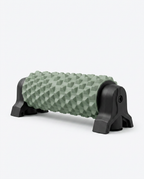 Green textured foam roller on a black wall-mount stand, studio shot on white