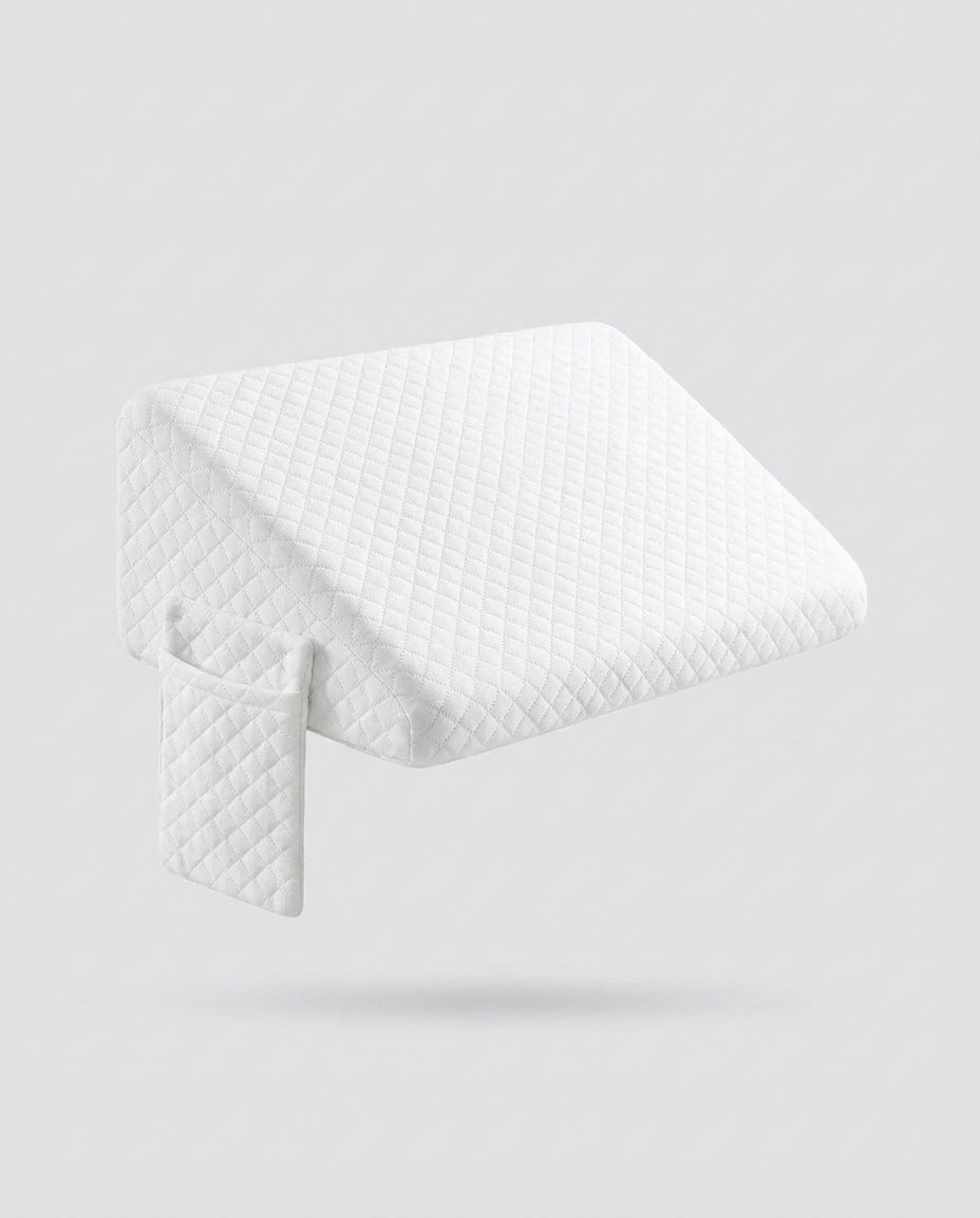 White quilted wedge pillow with detachable extension panel, floating on grey