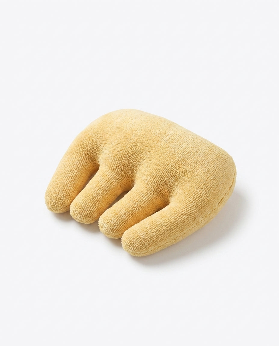 Yellow four-finger hand relaxation cushion lying on a white surface