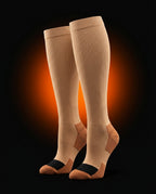 Pair of beige compression socks with copper heel on dark backdrop