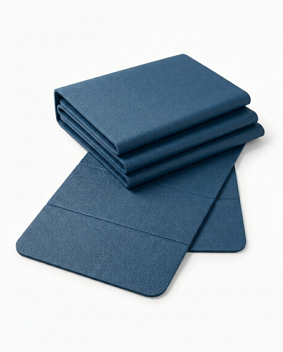 Navy blue foldable yoga mat shown folded and flat on white