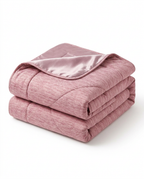 Folded pink cooling blanket with satin trim, studio shot on white