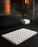 White bath mat in a dark spa bathroom with freestanding tub