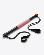 Pink-grip Pilates bar kit laid flat with bands and foot loops
