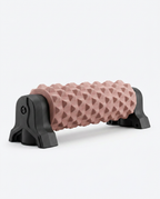 Pink textured foam roller on a black wall-mount stand, studio shot on white