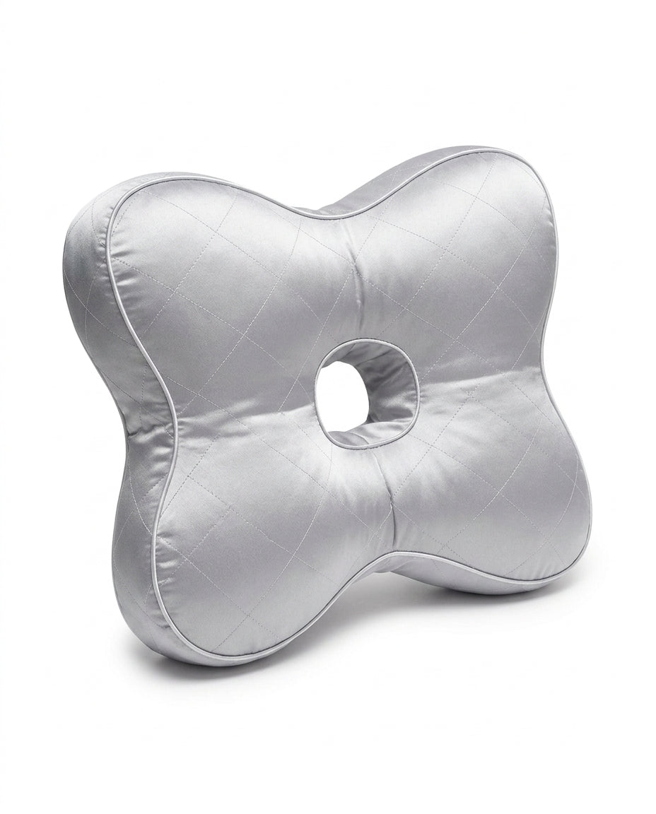 Silver quilted support pillow with central ear hole on white