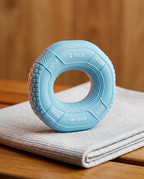 Sky blue grip strengthener ring standing on a folded towel