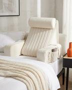 Cream white velvet bed rest pillow on a neatly made bright bed