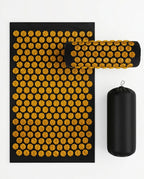 Amber-yellow spike acupressure mat, pillow and bag on a white background