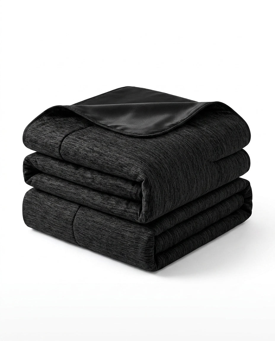 Folded black cooling blanket with satin trim, studio shot on white