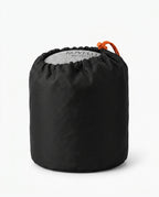 Travel neck pillow packed into a compact black drawstring carry bag
